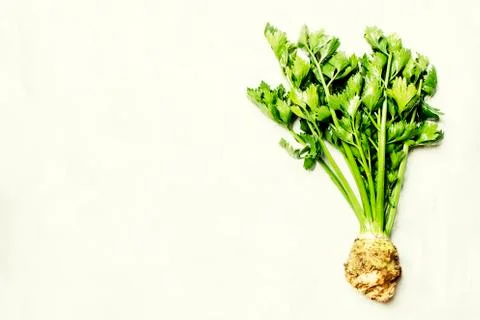 Raw root celery with green stems, gray stone background, top view Stock Photos