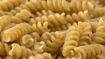 Raw rotini pasta low angle shallow depth of field with rotating movement Stock Footage 86060988