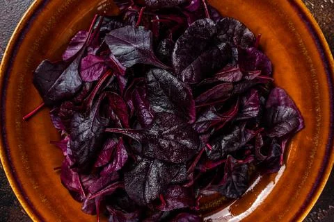 Raw Ruby or red chard salad Leafs on a rustic plate. Dark background. Top view 스톡 사진