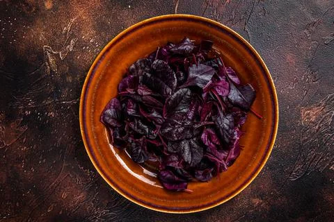 Raw Ruby or red chard salad Leafs on a rustic plate. Dark background. Top view Stock Photos