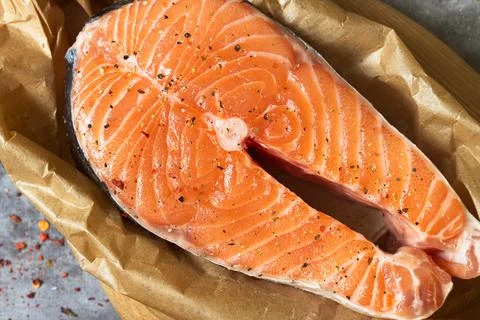 Raw salmon fish steak in baking paper Stock Photos