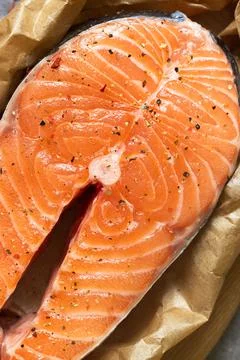Raw salmon fish steak in baking paper Stock Photos