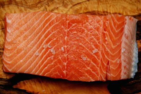 Raw salmon on olive tree cutting board Stock Photos