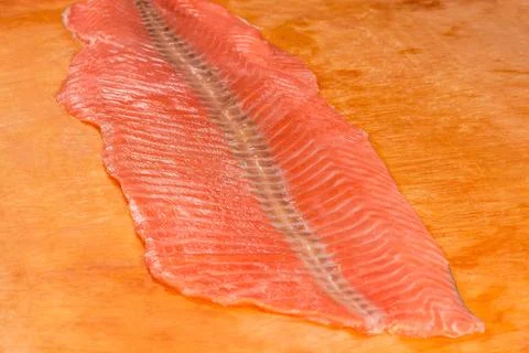 Raw salmon side part slice on cutting board, close-up Stock Photos