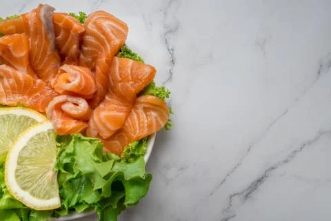 Raw salmon slice or salmon sashimi with green oak salad and lemon in Japanese Stock Photos