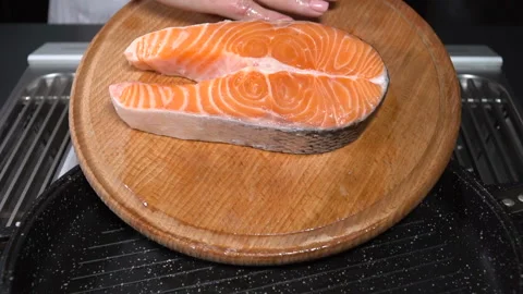 Raw salmon steak put in the pan. Slow motion Video stock 101734503