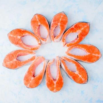 Raw salmon steaks pattern on a blue background top view 库存照片