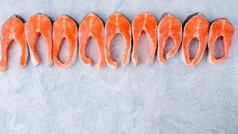 Raw salmon steaks pattern on a blue background top view Photos
