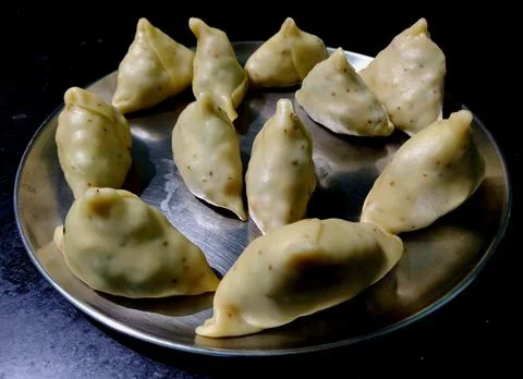 Raw samosas about to be deep-fried made up of grain flour and potatoes Stock Photos