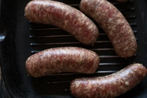Raw sausages on a pan Stock Photos