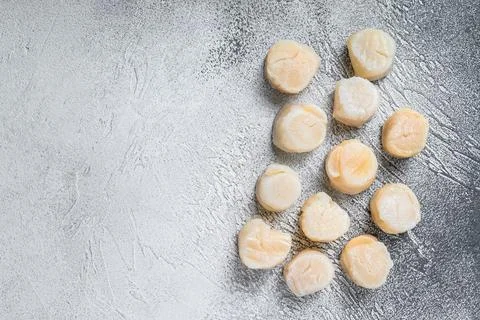 Raw scallops meat on a kitchen table. White background. Top view. Copy space Stock Photos