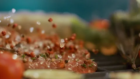 Raw seasoned meat steak placed on hot grill plate with falling red pepperco.. Stock Footage 337445918