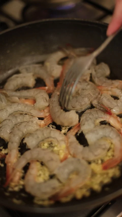 Raw shrimp in the process of cooking, stirred with a fork in a pan. Stock Footage 308489961