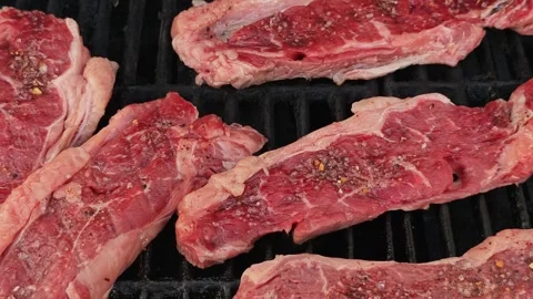 Raw Sirloin Cuts on Black BBQ Surface Seasoned with Salt and Black Pepper at Stock Footage 339217645