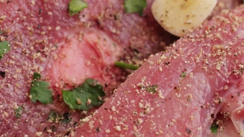 Raw slice beef meat in spices: paprika, salt, pepper, turmeric on plate close-up Stock Footage 265911991
