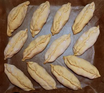 Raw small pies on a baking sheet for food background Foto stock