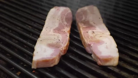 Raw Smoked Bacon Slice on a Hot Grill, Close-Up Footage Video stock 332814725