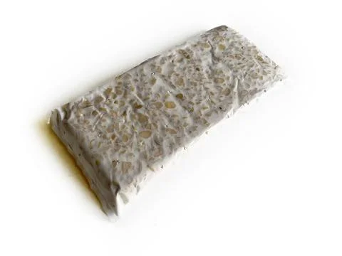 Raw soybean tempeh in plastic wrap Stock Photos