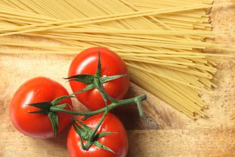 Raw spaghetti and tomatoes Stock Photos
