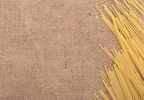 Raw spaghetti on the burlap background Stock Photos