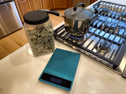 Raw spaghetti in container next to scale with stainless steel pot on top of.. Stock Photos