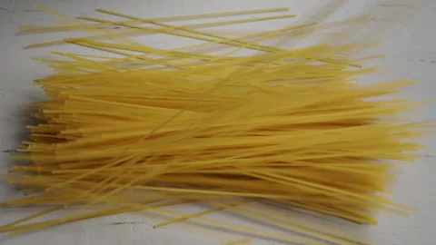 Raw spaghetti falling on table. Slow motion Video stock 143257844