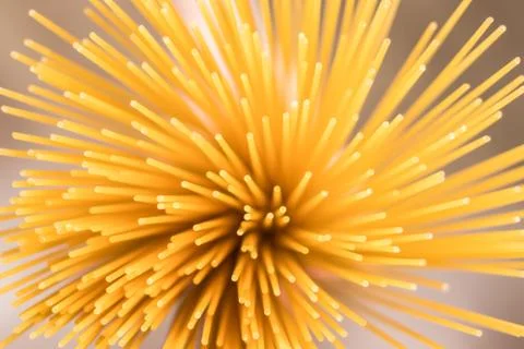 Raw spaghetti in hand, top-down view. Selective focus. Stock Photos