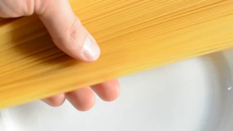Raw spaghetti pouring on plate. Stock Footage 73620070