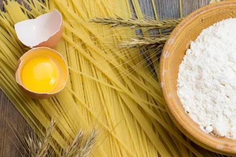 Raw spaghetti, wheat stalk, egg and flour Stock Photos