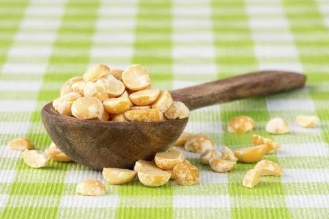 Raw split peas in a wooden spoon on checkered tablecloth Stock Photos
