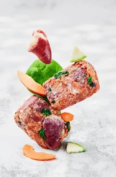 Raw square cutlets on a light background. Natural food for dogs. BARF dog diet Stock Photos