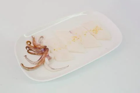 Raw squid slice on white dish isolate on white background ready to be grilled Stock Photos