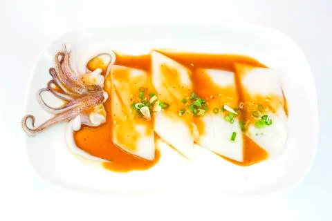 Raw squid slice on white dish isolate on white background ready to be grilled Stock Photos