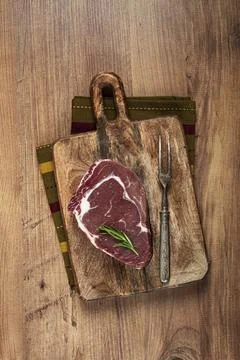 Raw steak, beef steak, rib eye steak, on a cutting board, freshly frozen, with Foto stock