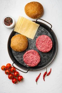 Raw steak cutlets with mince beef meat and rosemary on white stone table Foto stock