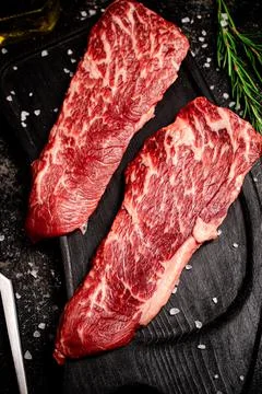 Raw steak on a cutting board. Stock Photos