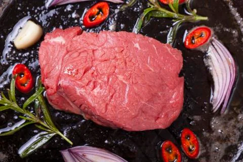 Raw steak in an iron pan Stock Photos