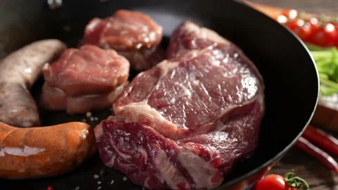 Raw steak meat beef sausages on a turntable pan on a wooden table 스톡 동영상 170314899