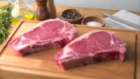 Raw steak meat on cutting board in bright kitchen	 Stock Footage 143128016