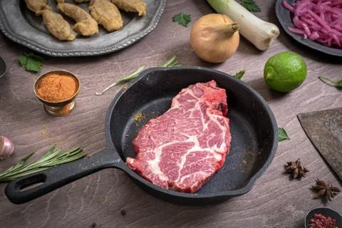 Raw steak on pan Fotos de archivo