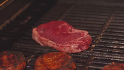 Raw Steak Resting on Hot BBQ Grill Ready to Cook. Outdoor Night Cooking. 動画素材 342272608