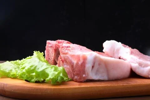 Raw steak on a rustic cutting board with salt, pepper and grinder for spices Stock Photos