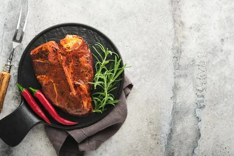 Raw steak t-bone or porterhouse. Steak t-bone or porterhouse in sauce with sp Stock Photos