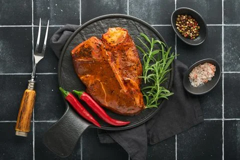 Raw steak t-bone or porterhouse. Steak t-bone or porterhouse in sauce with sp Stock Photos