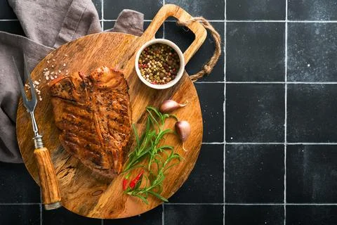 Raw steak t-bone or porterhouse. Steak t-bone or porterhouse in sauce with sp Stock Photos