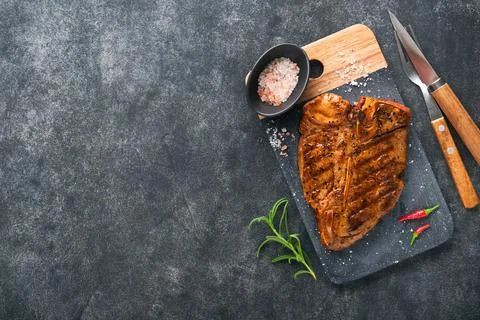 Raw steak t-bone or porterhouse. Steak t-bone or porterhouse in sauce with sp Stock Photos