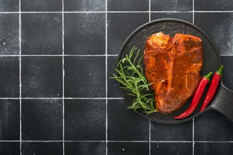 Raw steak t-bone or porterhouse. Steak t-bone or porterhouse in sauce with sp Stock Photos