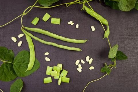 Raw string beans. Raw green string beans, whole and sliced, black surface.... Stock Photos