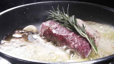 Raw strip steak fried in a pan Stock Footage 84778878