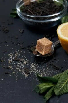 Raw tea with mint, spoon, sugar and lemon on a dark background Stock Photos